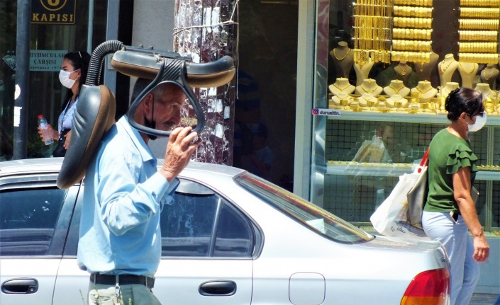 Sıcaktan korunmak isteyen vatandaştan ilginç yöntem: Kafasının üstünde koltukla yürüdü