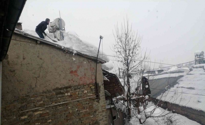 Arıcak’ta vatandaşlar, çatılarda biriken kar birikintilerini temizledi